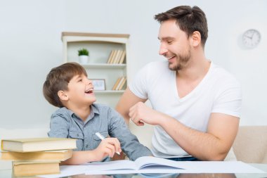 father checking homework of son. clipart