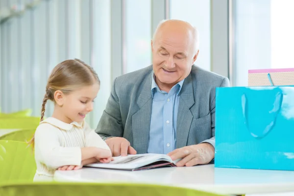 Neta lendo livro com o avô — Fotografia de Stock