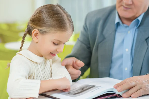 Nieta atentamente explorar un libro . — Foto de Stock