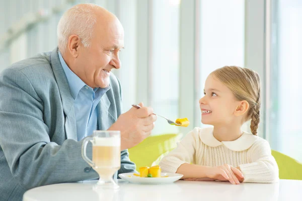 Grand-père demandant à sa petite-fille d'essayer une tarte . — Photo