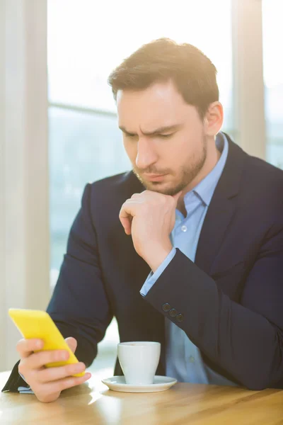 Uomo guardando preoccupato fissando il suo smartphone . — Foto Stock