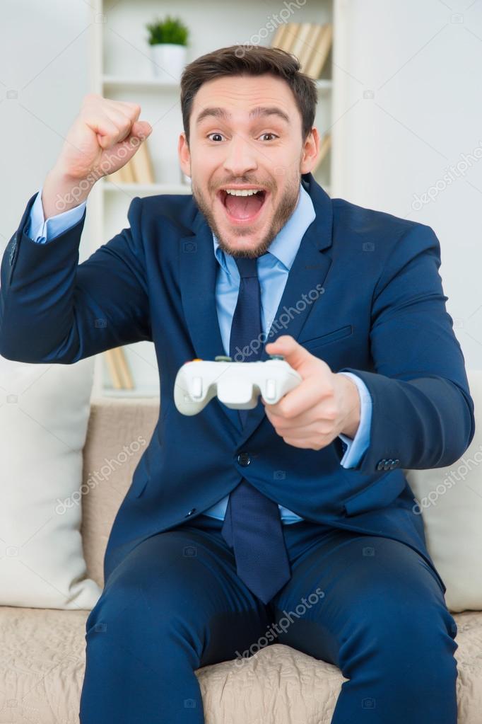 Man in suit playing video games Stock Photo by ©Dmyrto_Z 98488030
