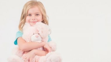 Gülümseyen kız onun oyuncak ayı sarılma.