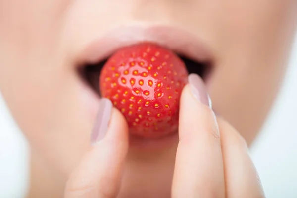 Улыбающаяся женщина ест клубнику — стоковое фото