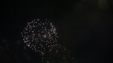 Gece gökyüzünde Bokeh ışıkları olan renkli altın rengi havai fişekler. Parlak ışıkların ve havai fişeklerin şenlikli arka planı. Yeni yılı kutluyoruz. Havai fişek festivali.