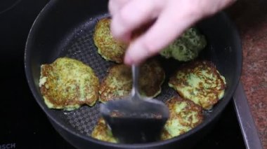 Metal spatula ile kızgın tavada sebzeli kabak böreği yapmak. Sağlıklı gıda tarımı.