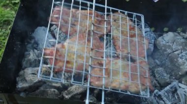 Et biftekleri, ızgarada yanan kömürlerin arka planında metal bir ızgarada kızartılır. Yemek pişirme ürünleri.