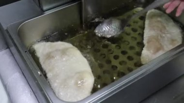 Metal bir kapta kızgın yağlı cheburekler pişirmek. Ulusal fırın ürünleri geleneksel yemek ve hamur işleri.