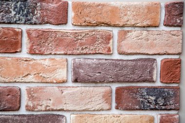 Arka plan düzensiz dikdörtgen şekilli, kırmızı ve terracotta renklerinde yapay tuğla duvarlardan yapılmıştır. Arkaplan, dokular, tasarım.