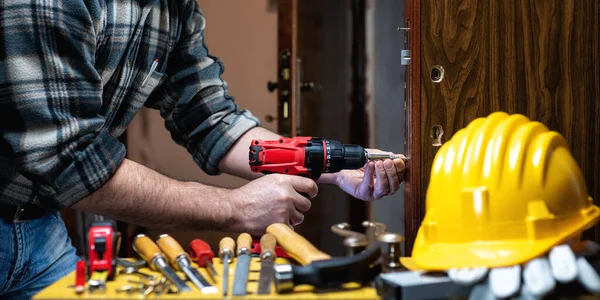 Close Carpenter Electric Screwdriver Fixes Lock Wooden Door Construction Industry — Stock Photo, Image