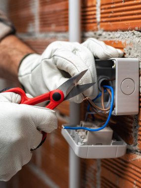 Makasla çalışan elektrik işçisi konut elektrik sisteminin elektrik kablolarını hazırlıyor. İnşaat endüstrisi.