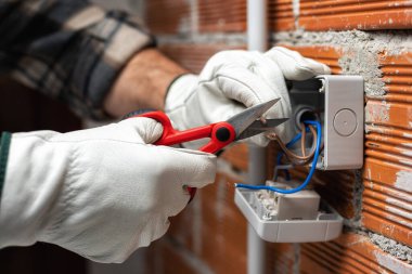 Makasla çalışan elektrik işçisi konut elektrik sisteminin elektrik kablolarını hazırlıyor. İnşaat endüstrisi.