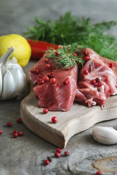 Carne di agnello crudo con spezie su tavola di legno sopra vecchio backgrou di legno — Foto Stock