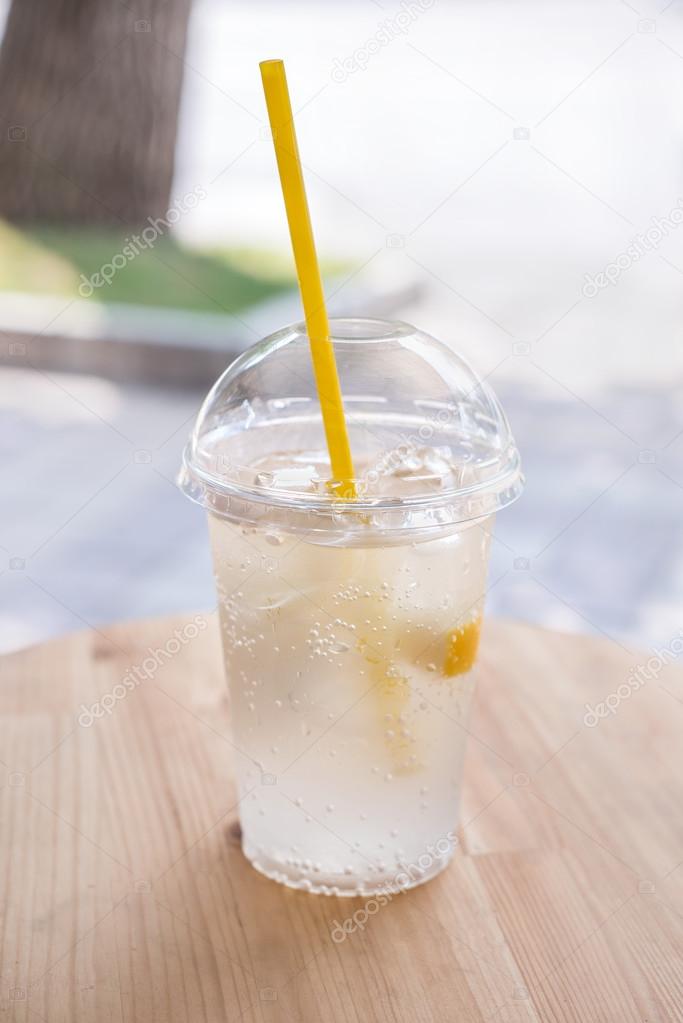 Lemonade,  a refreshing drink in a plastic cup.  Street backgrou