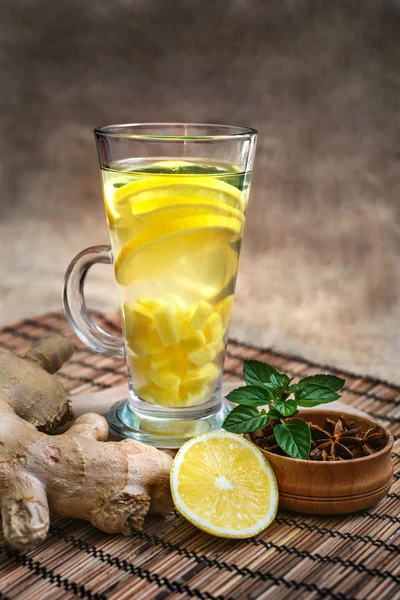 Tè allo zenzero con limone, radice di zenzero e menta su sfondo rustico — Foto Stock