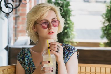 bir kafede limonata içmeye genç Avrupalı kadın