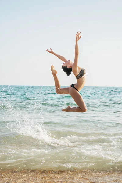 Gyönyörű női táncos Ugrás a strandon — Stock Fotó