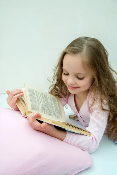 Klein meisje met verhaal boek in bed — Stockfoto