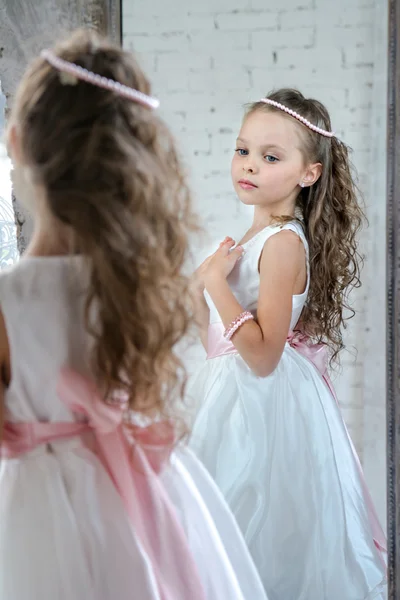 Маленькая девочка одевается перед зеркалом . — стоковое фото
