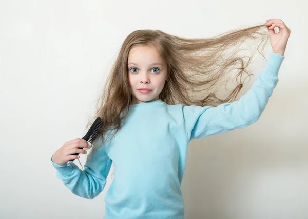 Bonito sorridente menina penteando seu pente de cabelo faz o cabelo — Fotografia de Stock