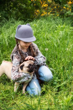 Küçük kız kırsal alanlarda onu pug köpek açık havada oynarken