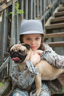 Küçük kız kırsal alanlarda onu pug köpek açık havada oynarken