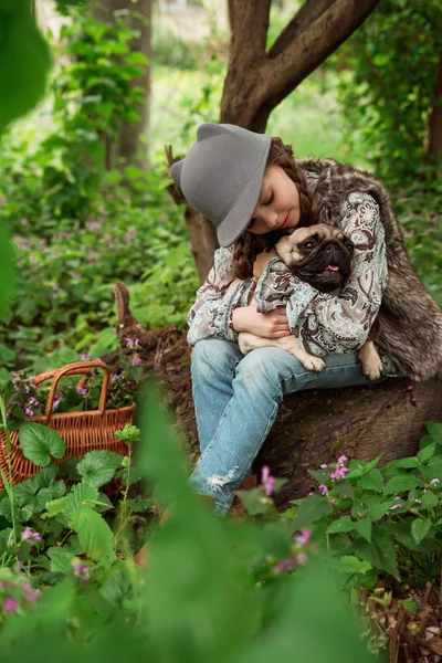 Little girl playing with her pug dog outdoors in rural areas — Stock Photo, Image