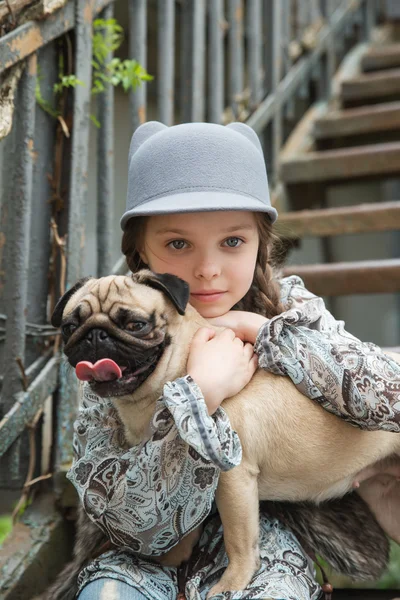 Little girl playing with her pug dog outdoors in rural areas — Stock Photo, Image