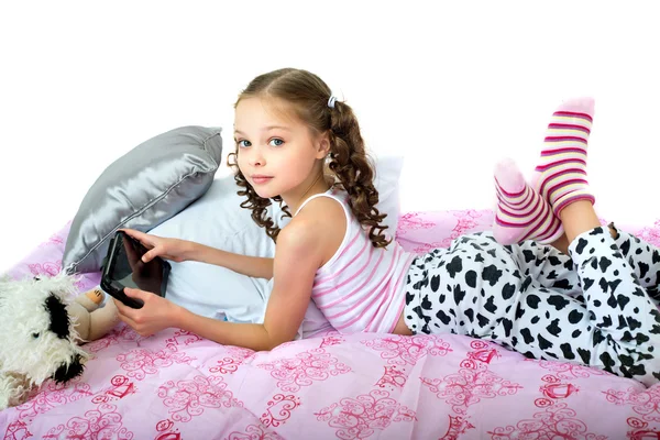 tablet bilgisayarınızla yatakta yatarken mutlu küçük kız
