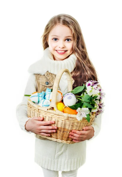 Lächelndes kleines Mädchen mit Korb voller bunter Ostereier — Stockfoto