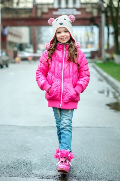 Niña con chaqueta de ping caminando por la ciudad. Sonriente chi — Foto de Stock