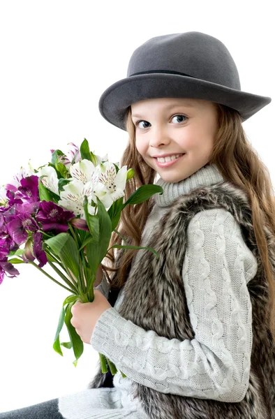 Dulce niña con sombrero y flores ramo en las manos — Foto de Stock