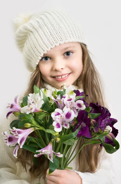 Dulce niña con sombrero y flores ramo en las manos —  Fotos de Stock
