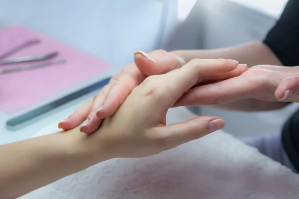 Frauenhände in einem Nagelstudio, die eine Handmassage von einem Strampler erhalten — Stockfoto