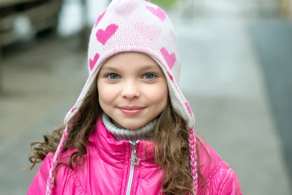 Маленька дівчинка в куртці для пінгу, що йде містом. Усміхнений ци — стокове фото