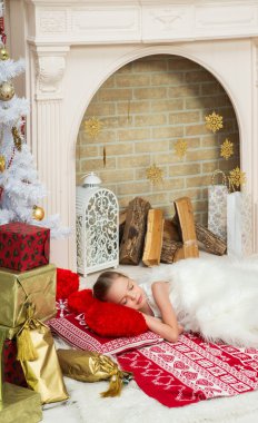 Güzel elbiseli küçük kız İsa'nın yanı sıra evde uyuyor