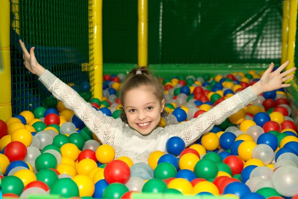 Little girl having fun playing with colorful plastic balls — Stock Photo, Image