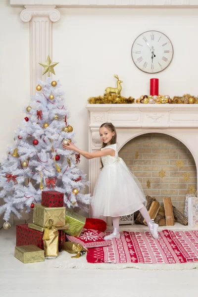 Petite fille en belle robe décore le sapin de Noël Photos De Stock Libres De Droits