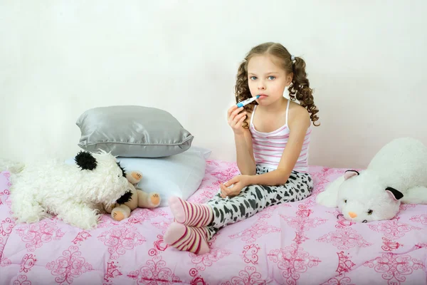 Cute Little Ill dziewczyna z termometru na łóżku. — Zdjęcie stockowe