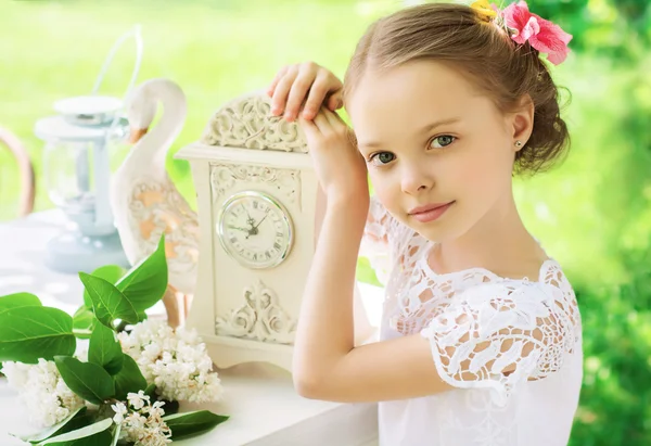 Little smiling girl with big clock. People, time management and