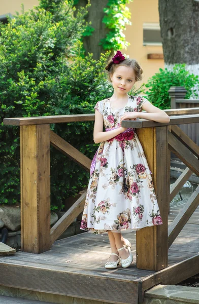 Niña en vestido colorido y flores . — Foto de Stock