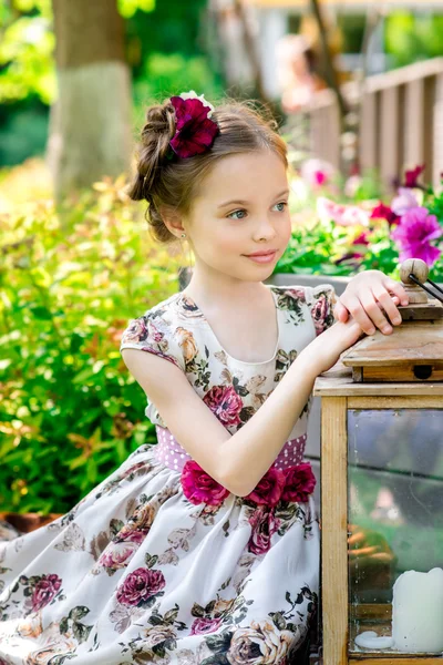 Liten flicka i färgglada klänning och blommor. — Stockfoto