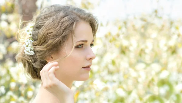 Schöne junge Frau mit Blumen im Haar — Stockfoto