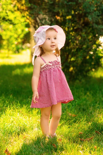 Niña sonriente en un prado en el parque . — Foto de Stock