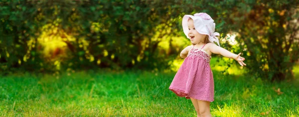 Mosolygó kislány egy réten a parkban. — Stock Fotó