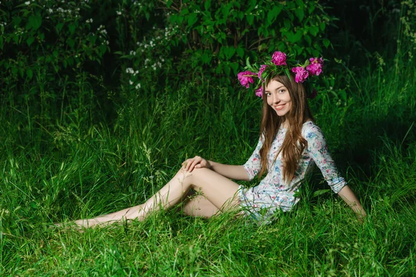 Beautiful young woman with beautiful legs in green spring grass — Stock Photo, Image