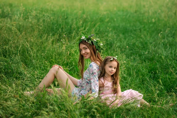 Životní styl portrét matka a dcera sedí na trávě v — Stock fotografie