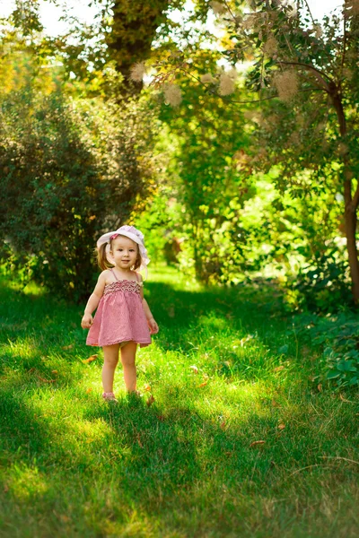 Parkta bir çayırda gülümseyen küçük kız. — Stok fotoğraf