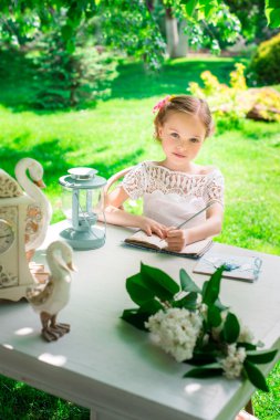 Küçük gülümseyen kız parkta dizüstü bilgisayar ayazı. Vı