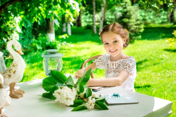 Petite fille souriante écrivant sur ordinateur portable en plein air dans le parc. Vi — Photo